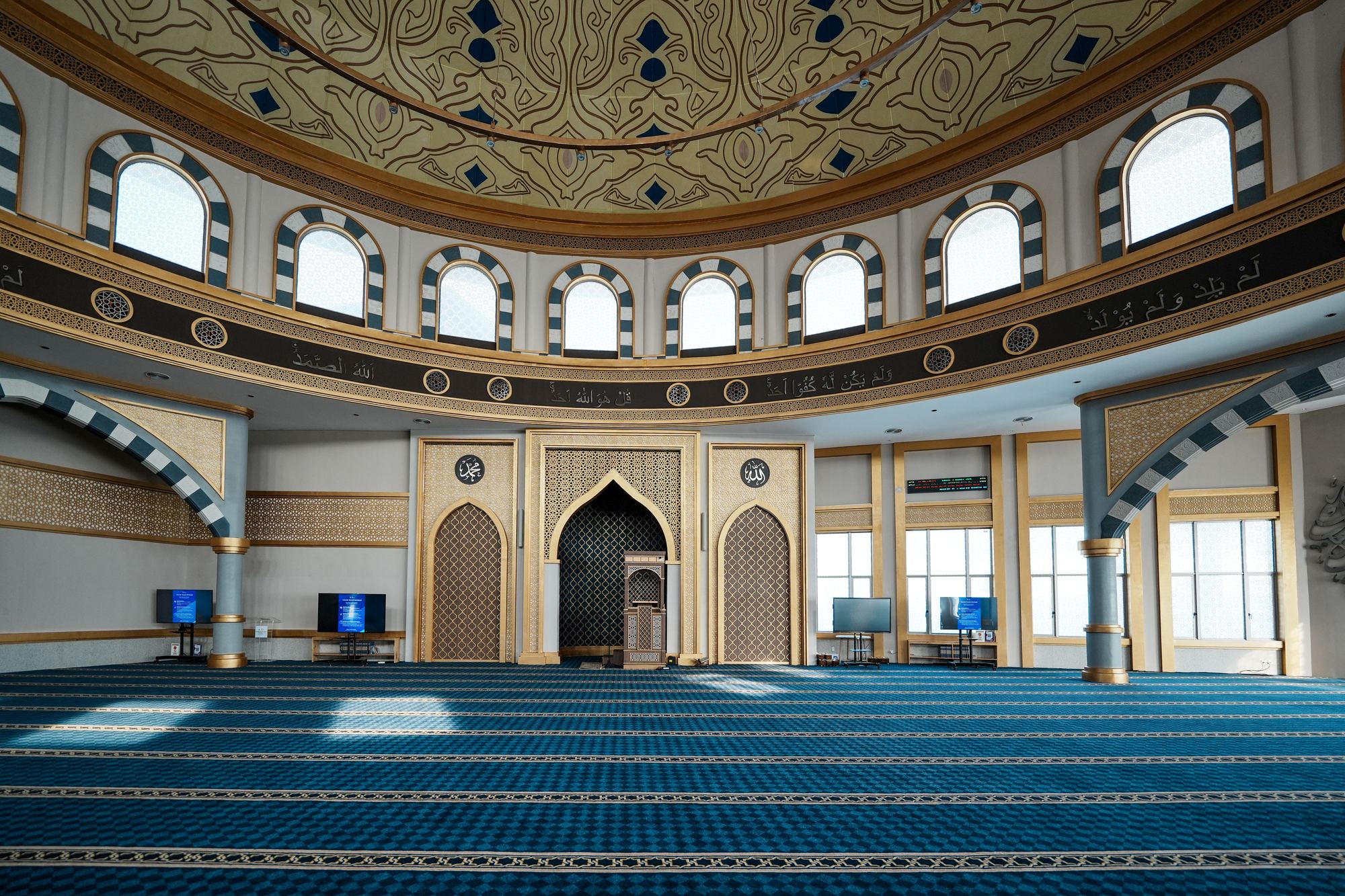 Grand mosque prayer hall with blue striped carpet